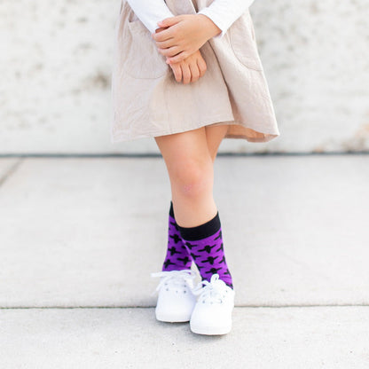 girl wearing white shoes and Purple socks with black ash crosses that say "repent and believe in the gospel' across the toe